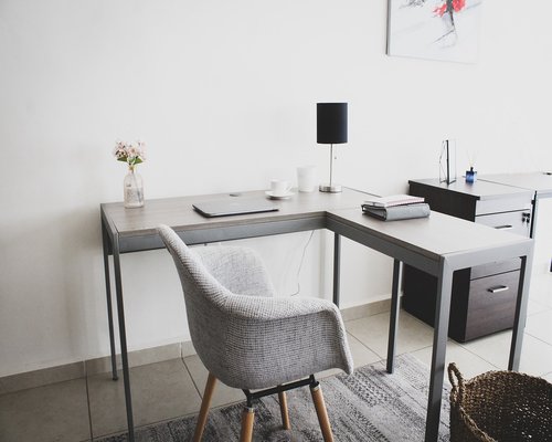 Organized work desk with natural light, a notebook, and water glass